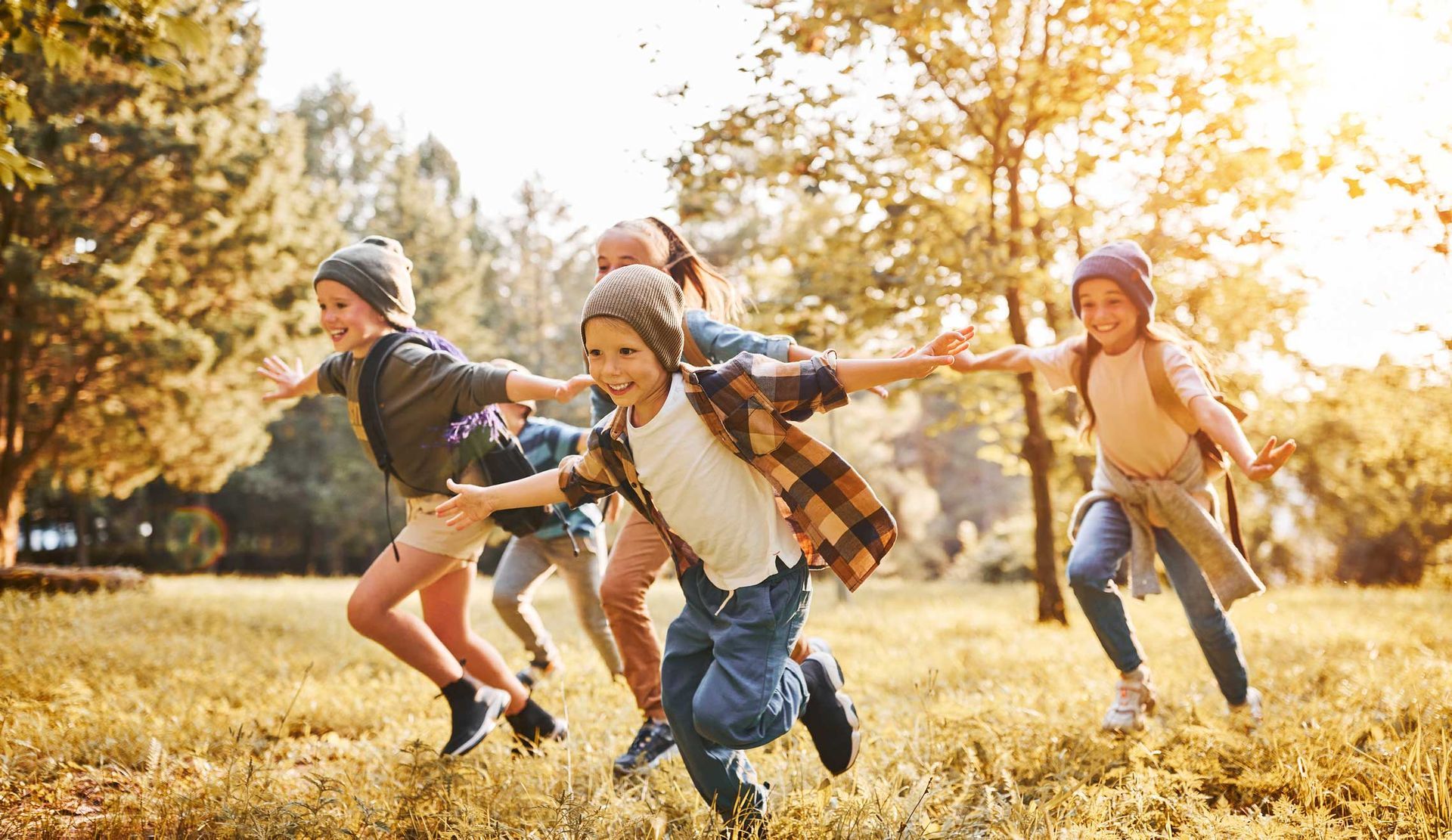 A group of children are running in a park.