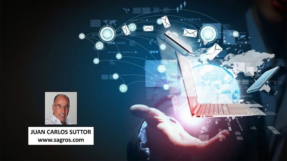 Juan Carlos Sutton sostiene una computadora portátil en su mano.