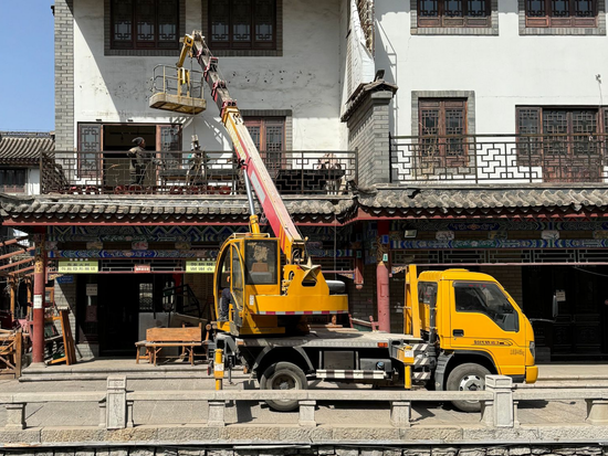 Construction site utilizing a boom truck to lift workers
