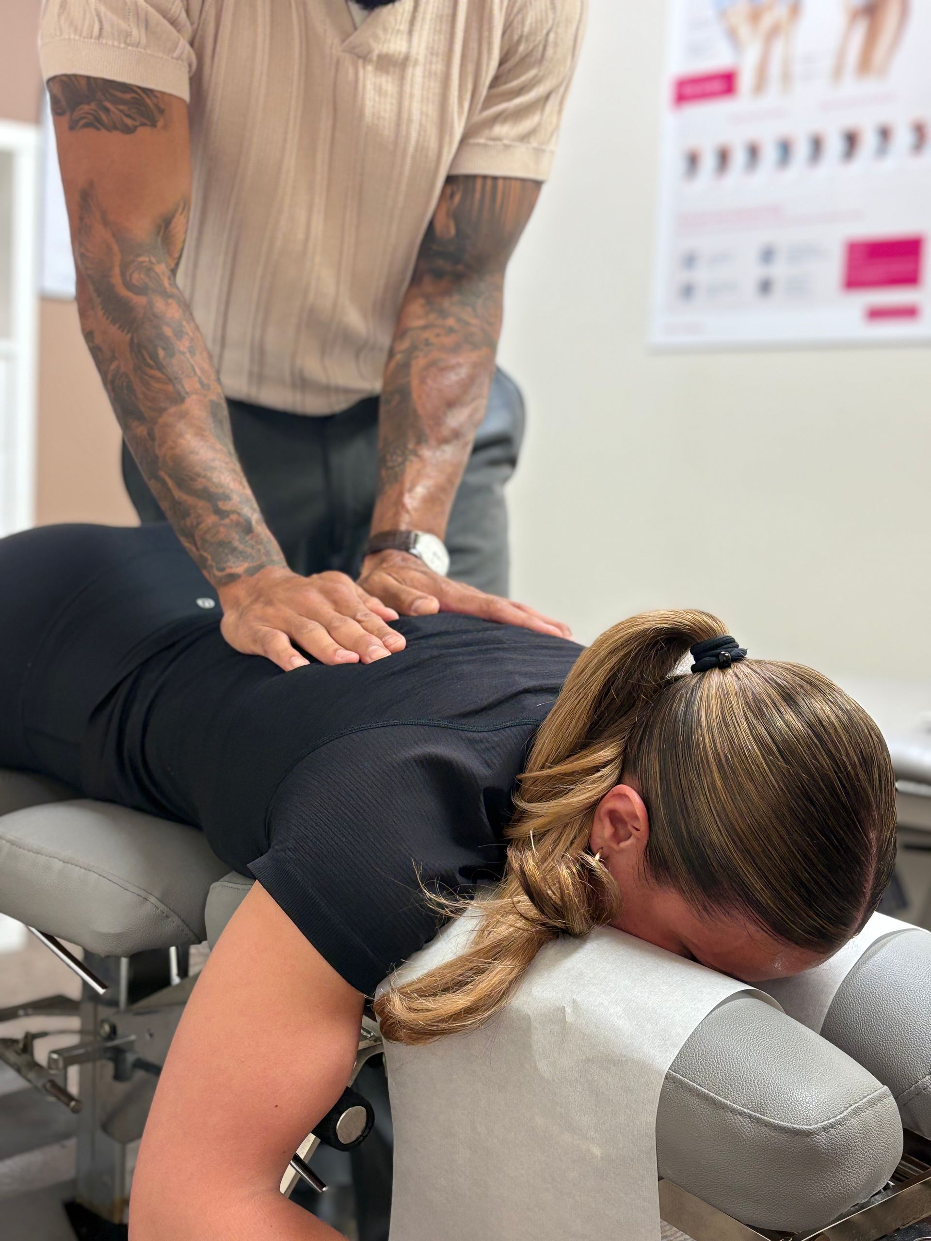 A chiropractor adjusts a patient lying face down on a treatment table.