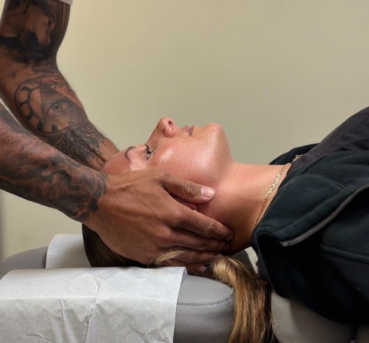 Person receiving a facial massage on a treatment bed in a spa room
