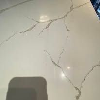 Cracked white tile floor with gray veins and a dark shadow in the lower left corner