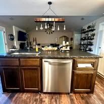 Modern kitchen with dark wood island, stainless steel dishwasher, and hanging light fixture