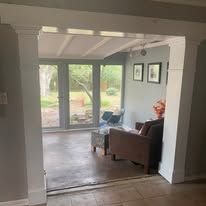 Living room with sliding glass doors, wood floor, and a brown armchair near framed wall art