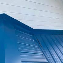 Blue corrugated metal wall and ceiling corner with white slatted panels above