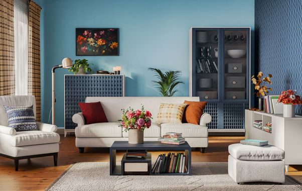 Modern living room with a white sofa, patterned blue walls, armchairs, and colorful decor