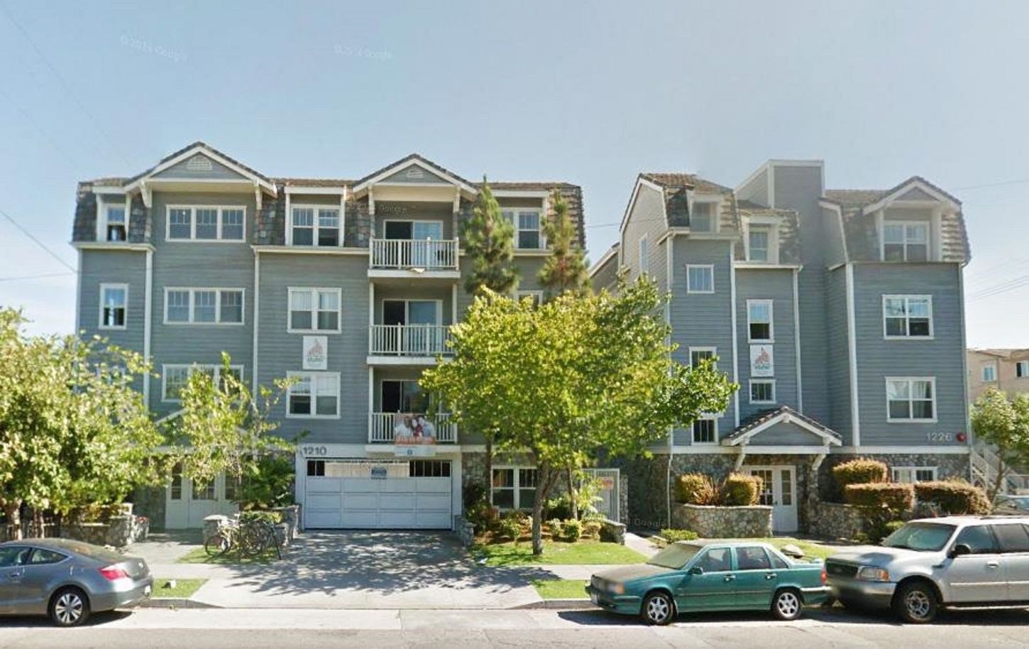 A large apartment building with cars parked in front of it
