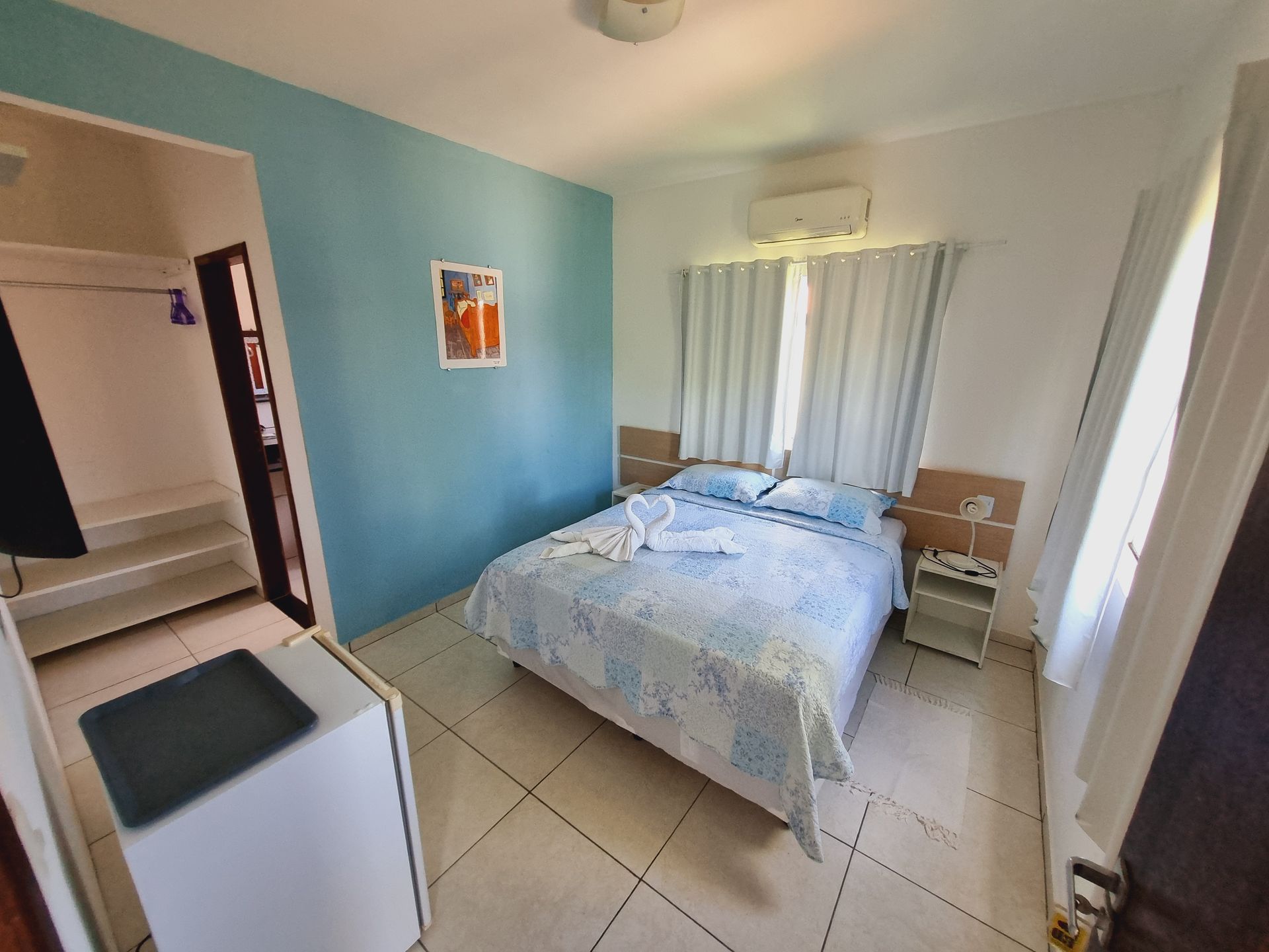 Um quarto com uma cama grande e uma parede azul Pousada Cantinho da Melão