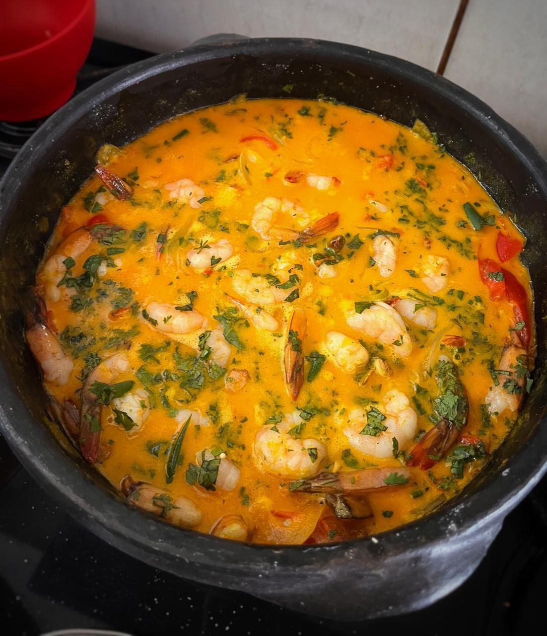 Uma panela de ensopado de camarão está cozinhando no fogão.Cantinho da Melão