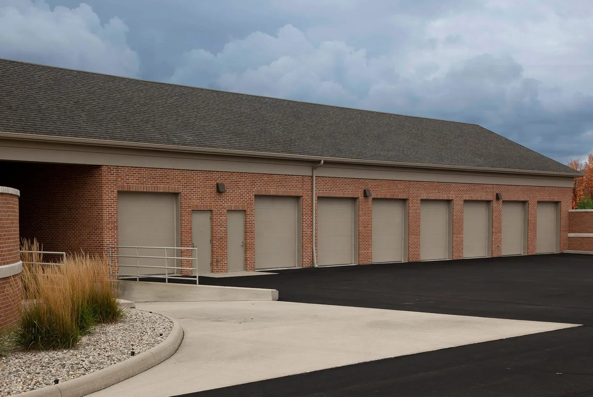 .Large Garage Door Commercial Brick building with several garage doors under a gray roof, .