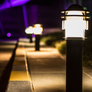 Lit walkway with black lamp posts and purple lighting at night