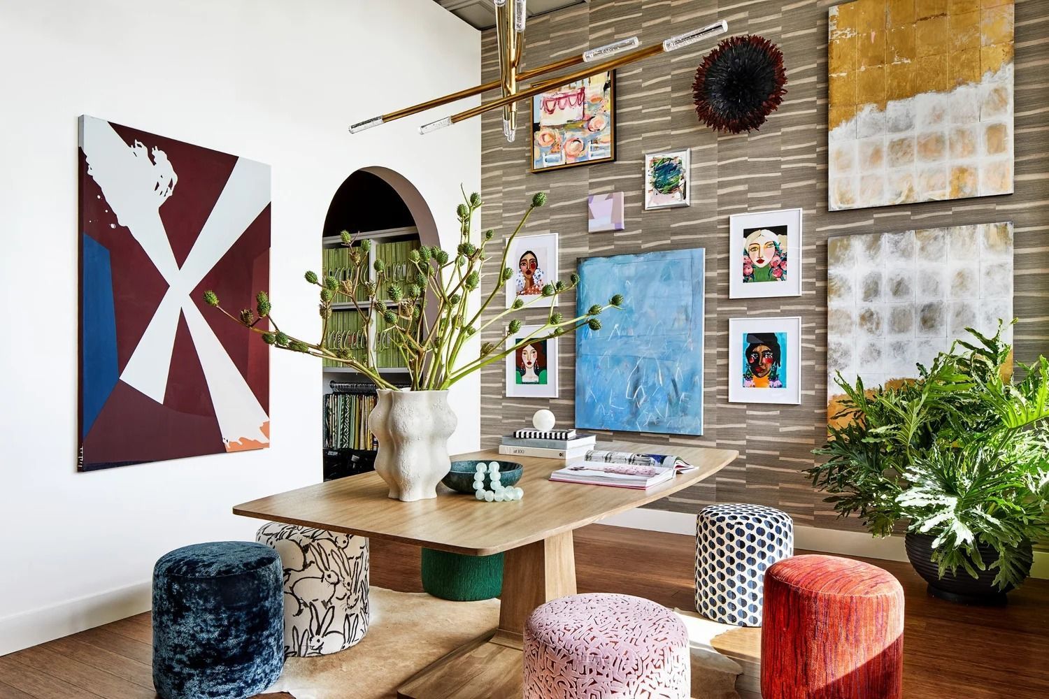 Dining room with art-filled walls, a wooden table, and patterned stools.