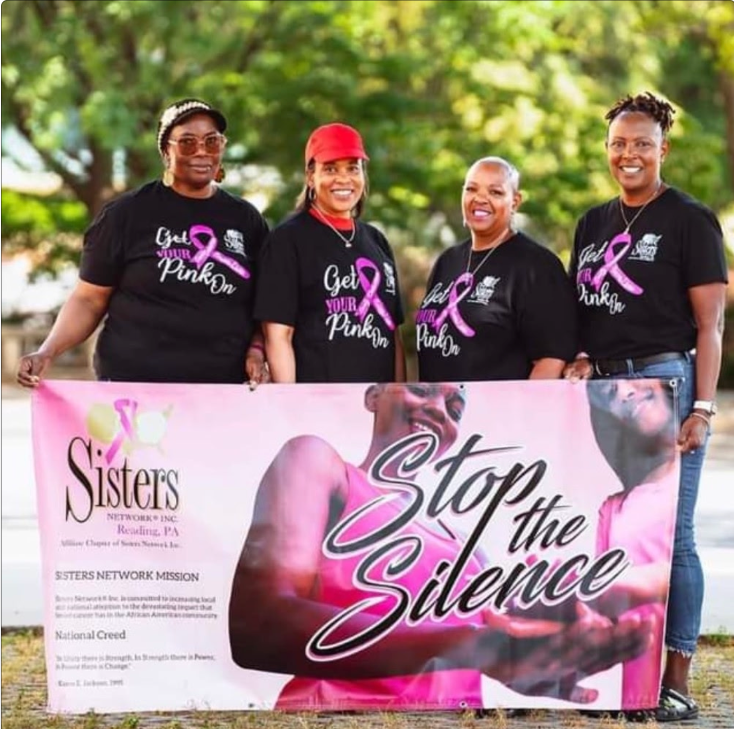 Four women holding a banner, 
