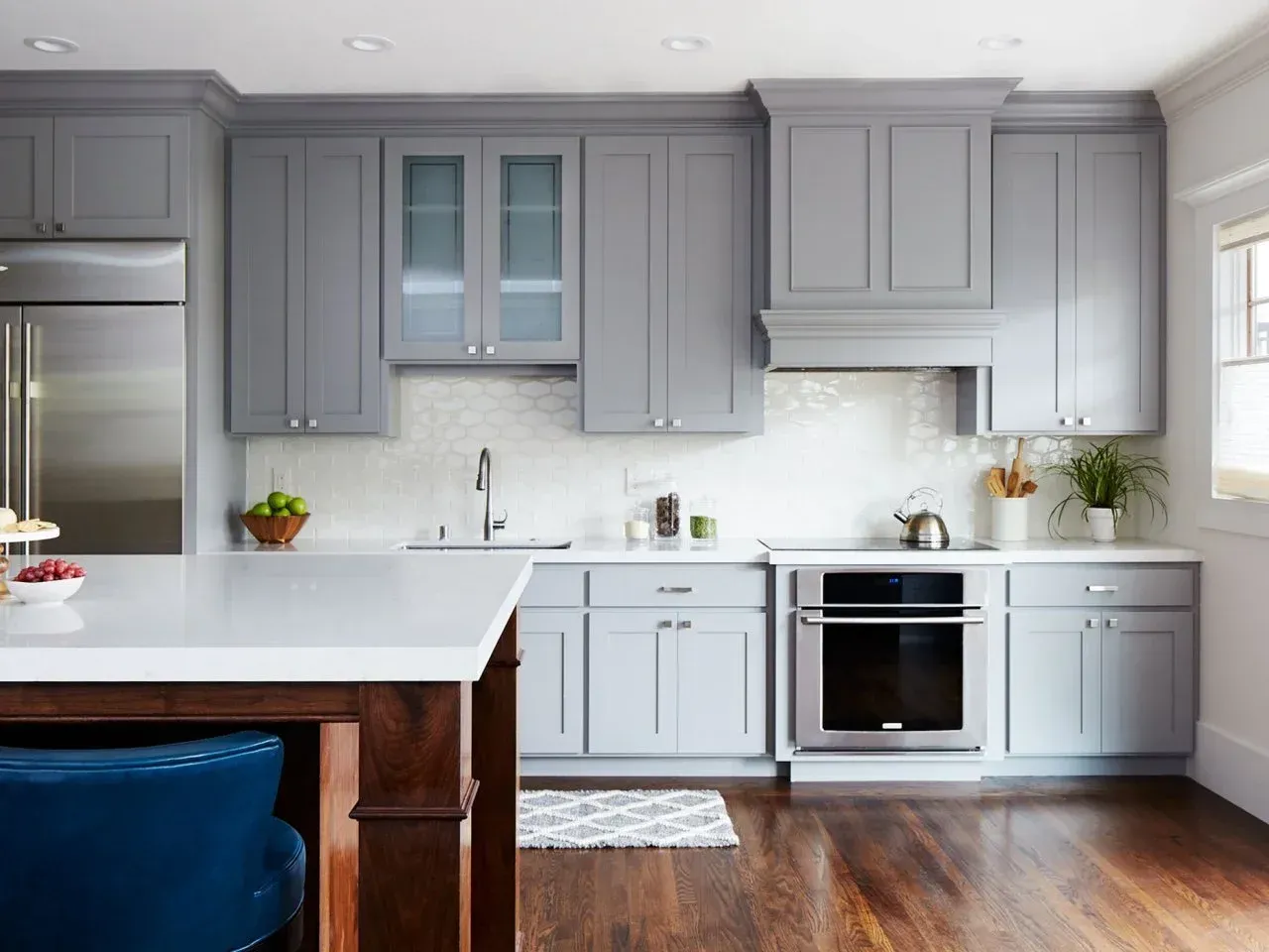 Gray kitchen with white countertops and dark wood floor.