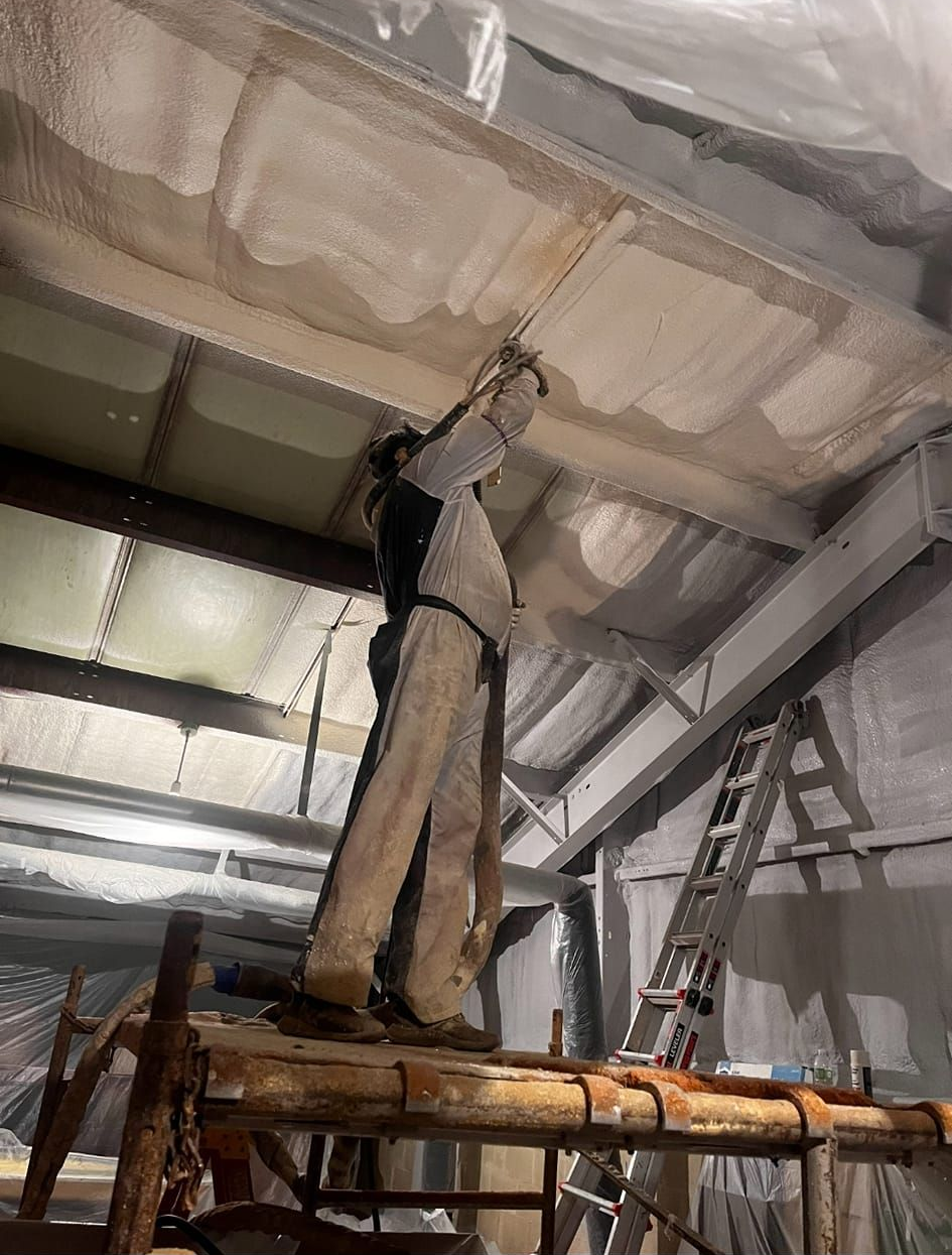 A vintage-looking wooden structure inside a large, dimly lit industrial building.