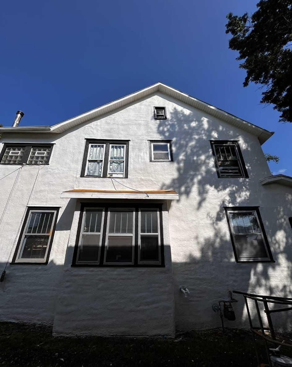 White house with multiple windows against a clear blue sky.