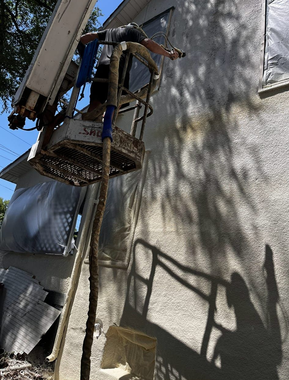 A person on a lift working on the side of a building.