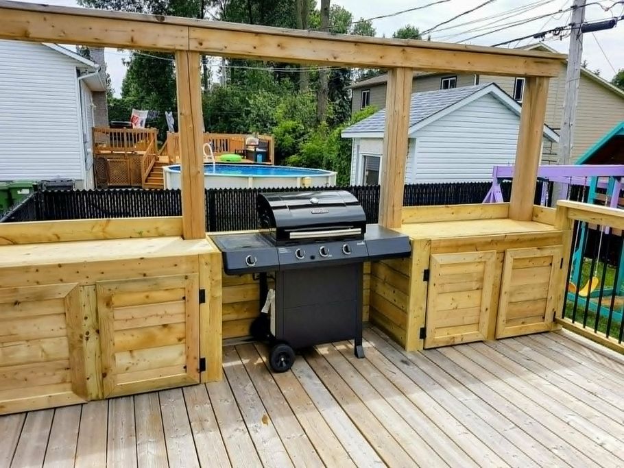 Terrasse arrière avec bar en bois intégré et barbecue noir sous une pergola en bois