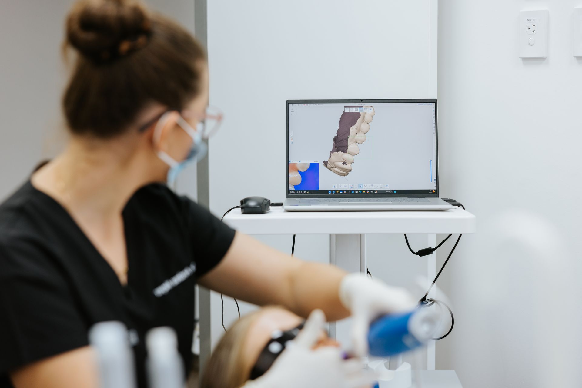 Dentist using a digital scanner on a patient, viewing 3D scan on a laptop in a dental office. — McDonald Dental in Gympie, QLD