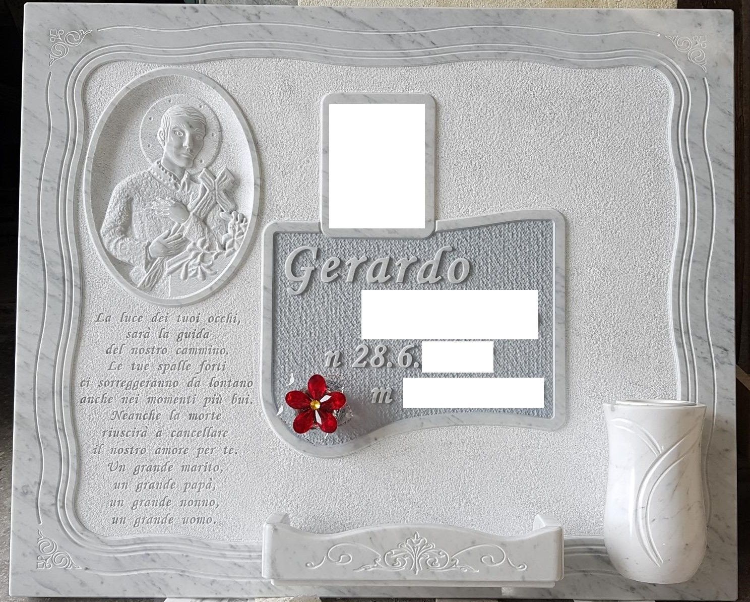 Targa commemorativa bianca con ritratto inciso, targhetta con il nome e decorazione floreale rossa.