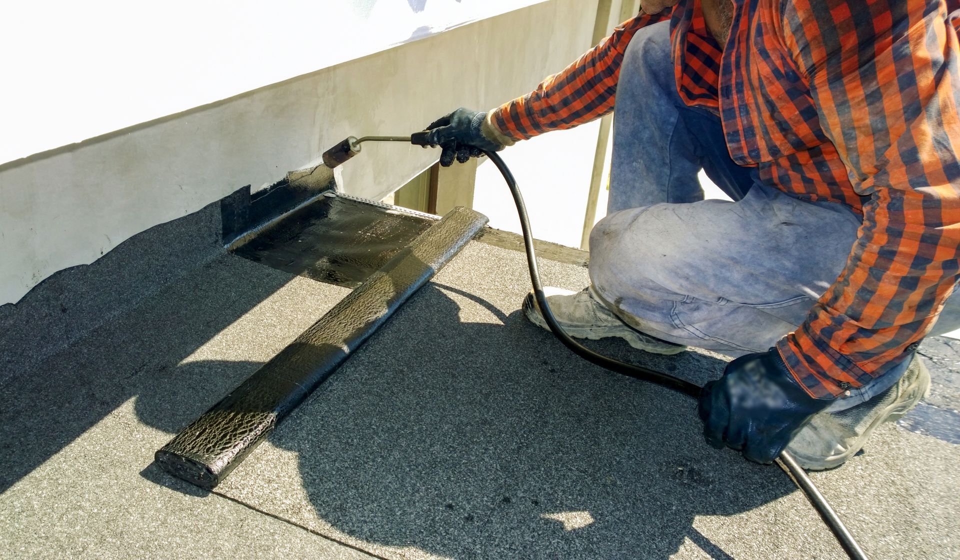 Roofer preparing part of bitumen roofing.