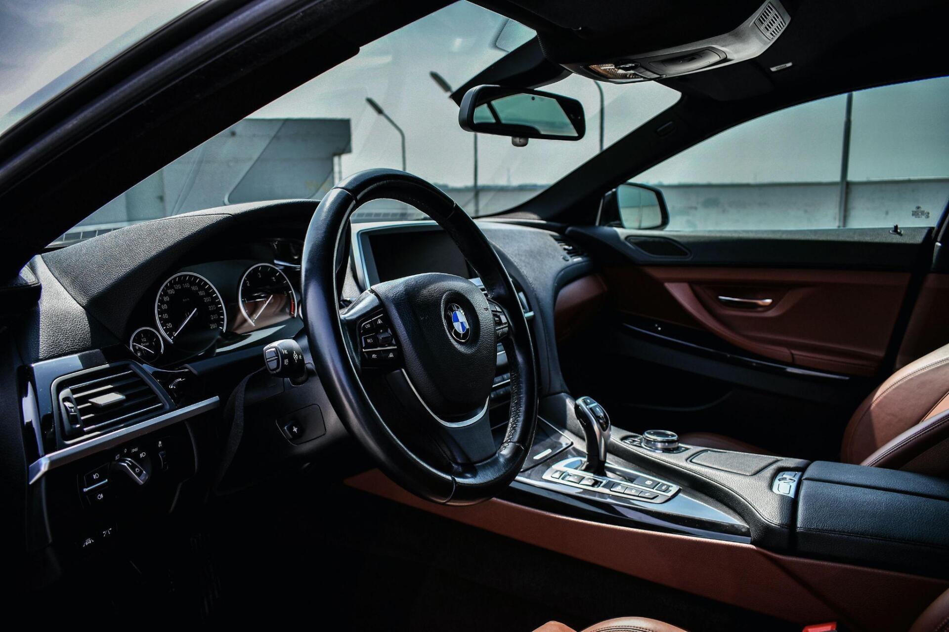 The inside of a car with a steering wheel and dashboard.