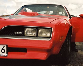 A red car with a license plate that says 6