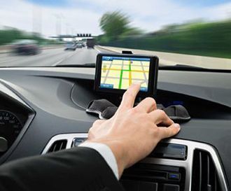 A man in a suit is using a navigation system in his car
