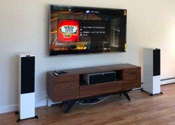 A living room with a flat screen tv and speakers