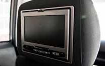 A headrest mounted dvd player in a car.