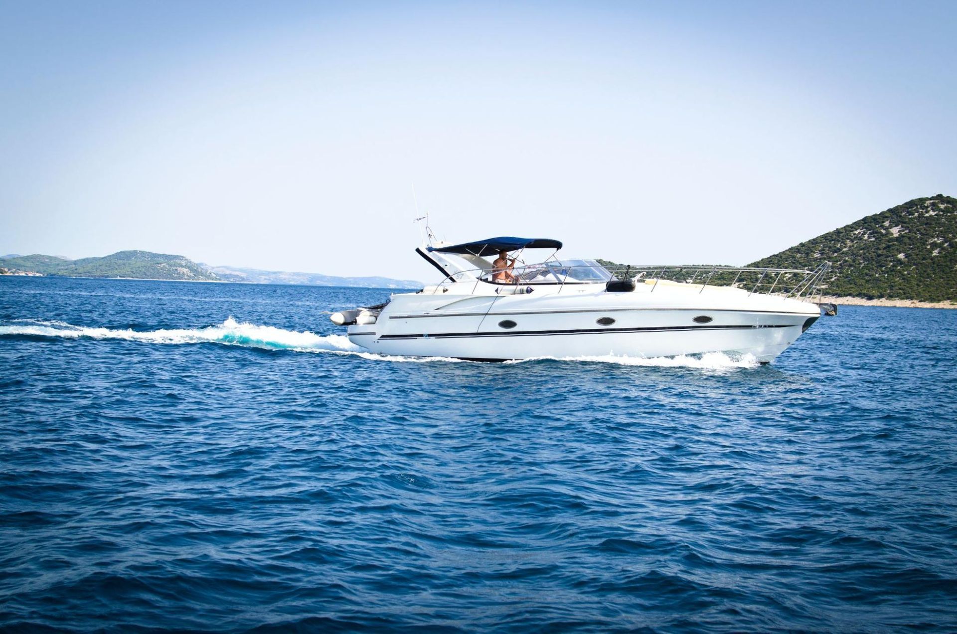 A white boat is floating on top of a large body of water.