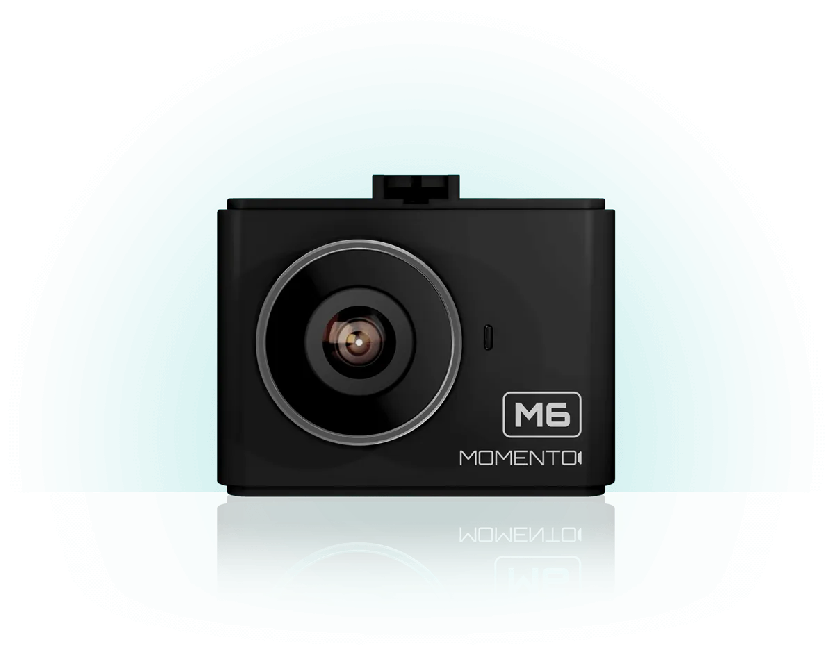 A black camera is sitting on a white surface.