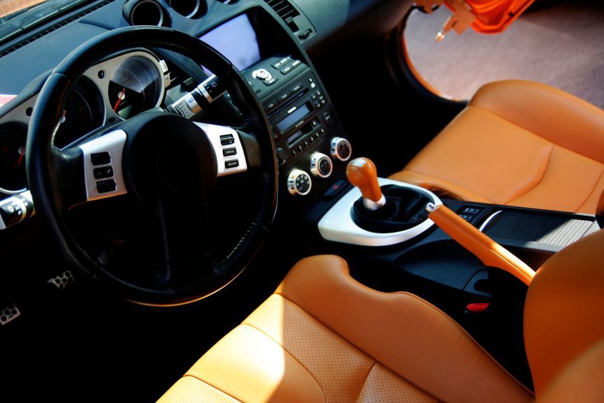 The interior of a car with brown leather seats and a steering wheel