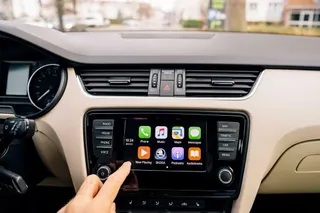 A person is pressing a button on a car radio.