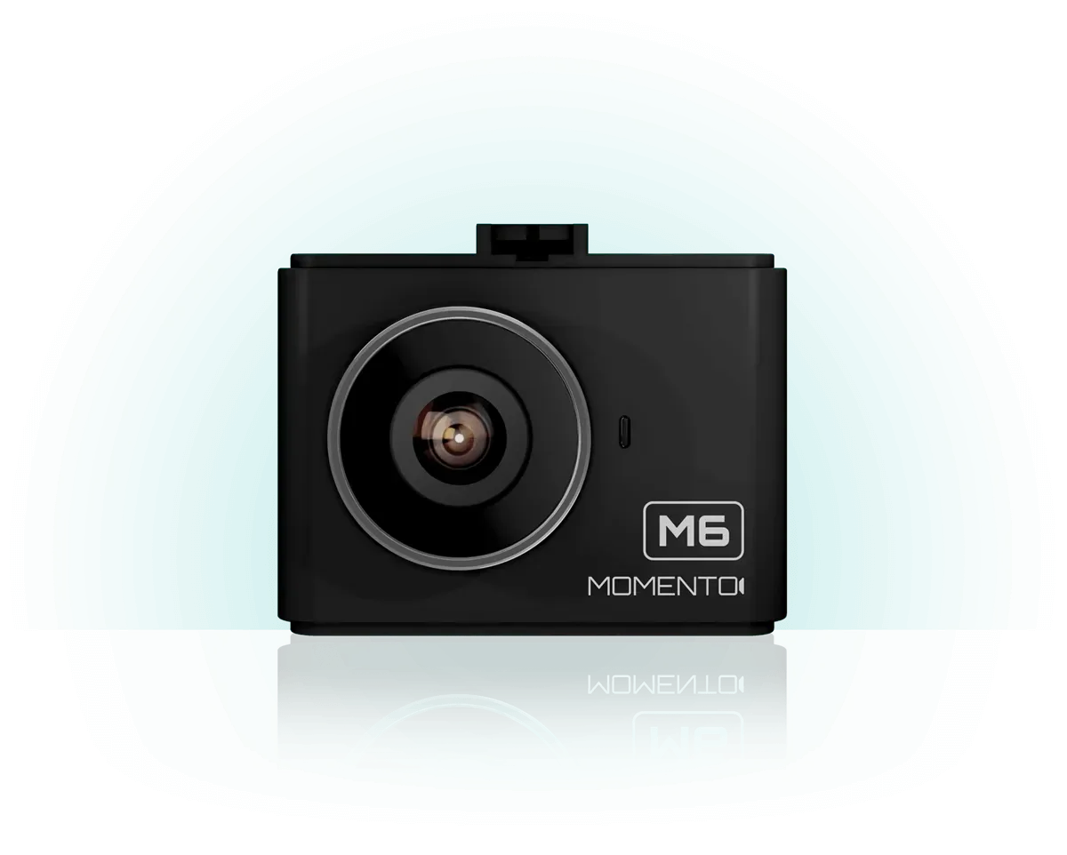 A black camera is sitting on a white surface.