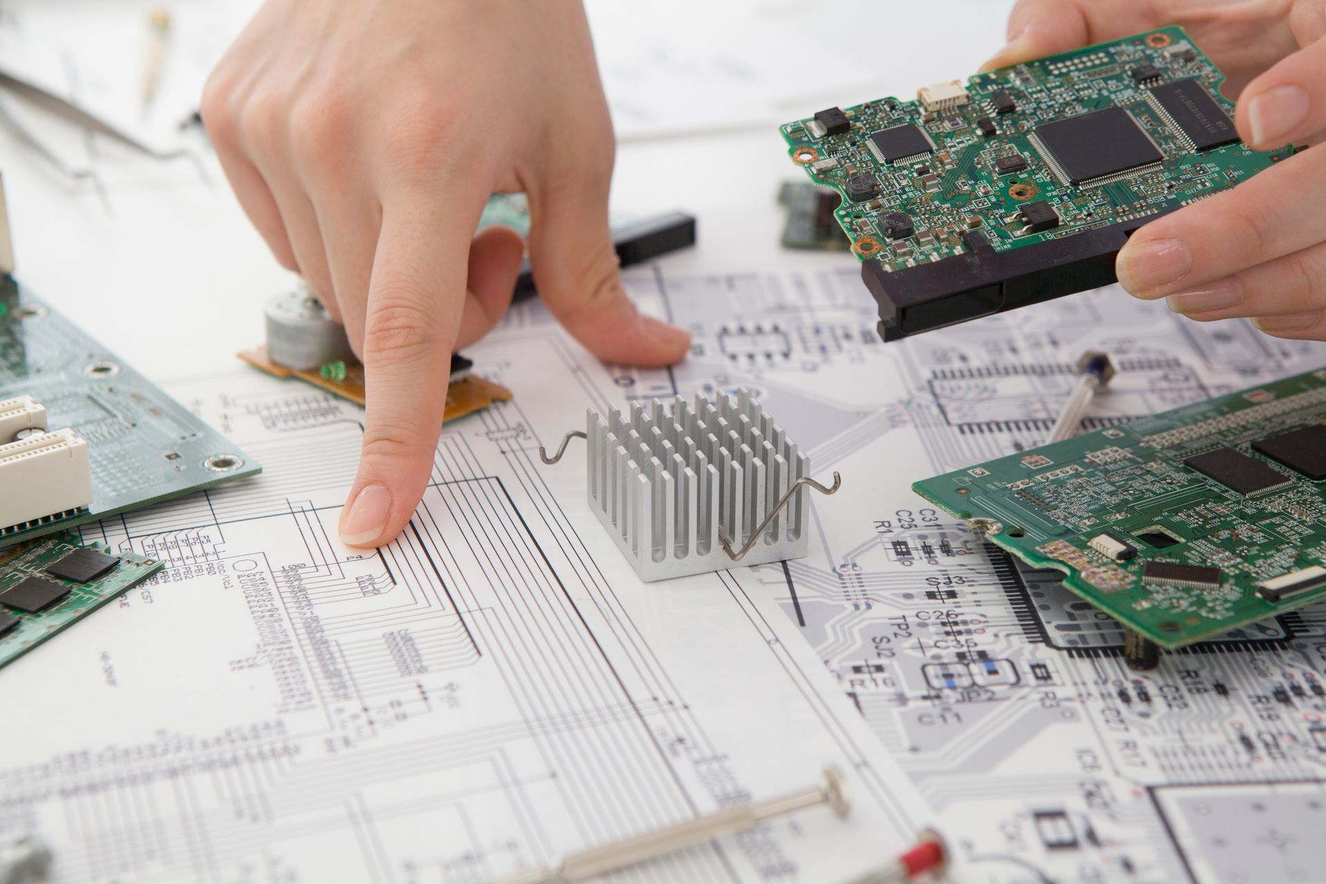 man pointing at schematics and holding a populated electronic prototype bard