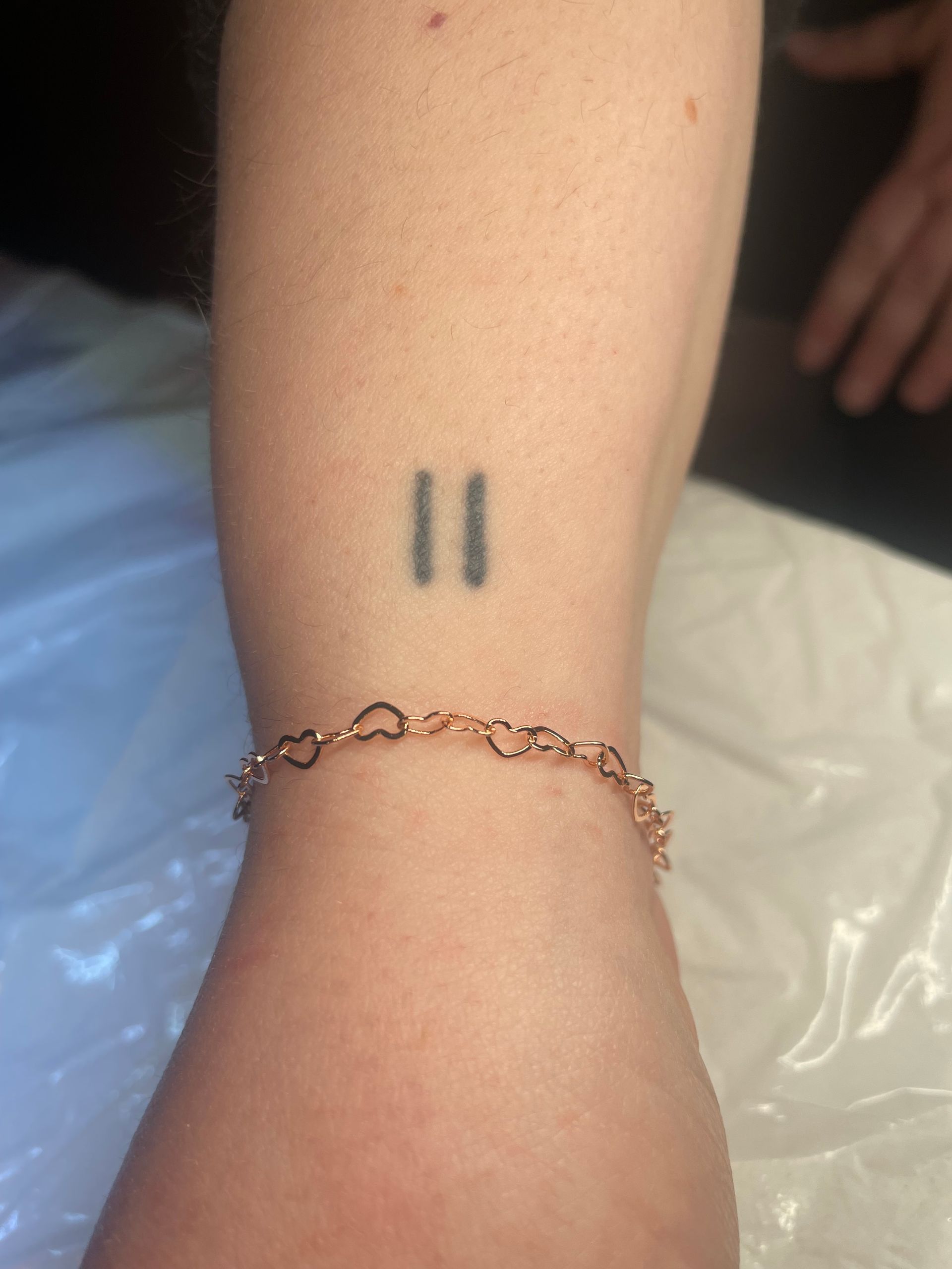 A woman has a tattoo on her wrist that says 11