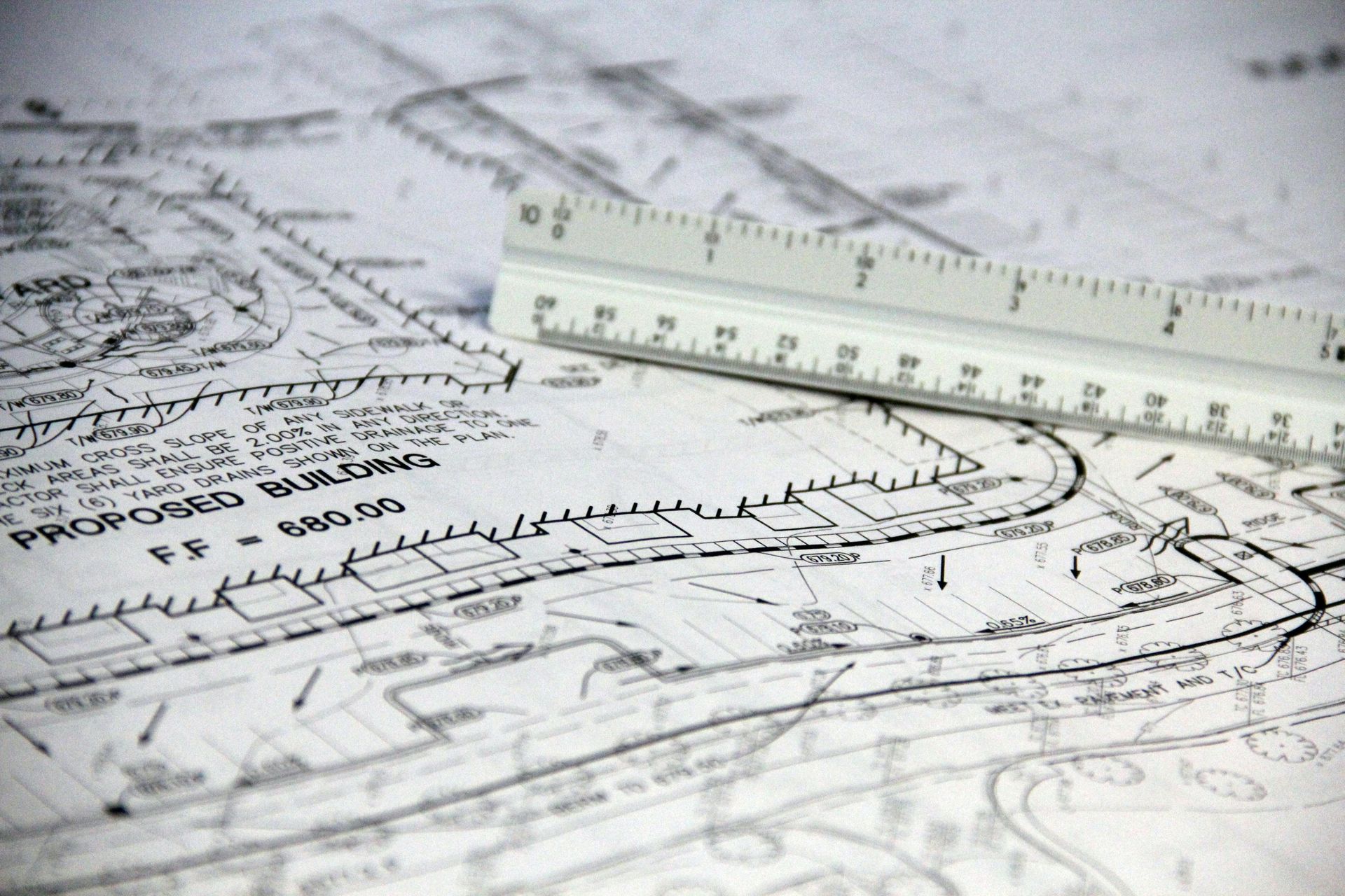 Architectural blueprints with a ruler measuring a technical drawing
