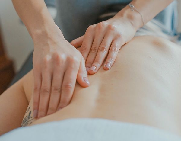 Hands giving a back massage on a person lying face down