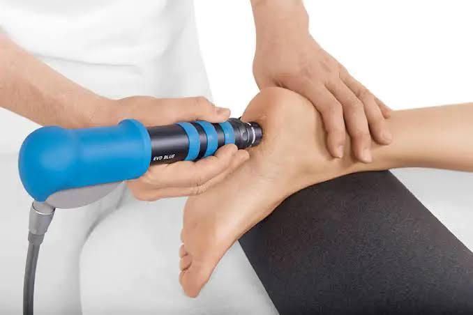 Physical therapy device massaging an ankle on a treatment table