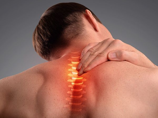 Person clutching neck and shoulder with glowing pain overlay on spine