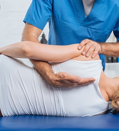 Chiropractor adjusting a patient’s leg on a treatment table