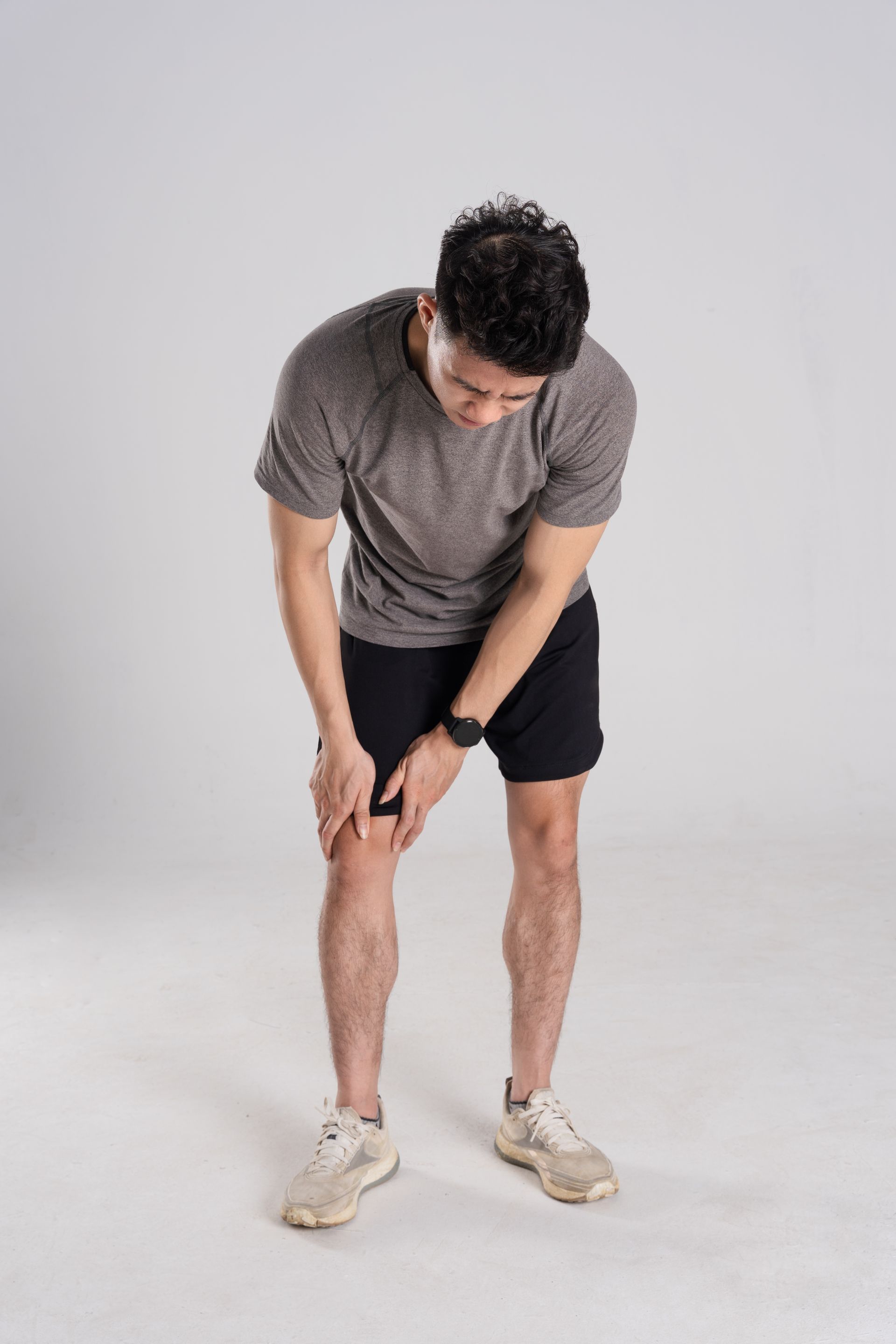 A man is holding his knee in pain.