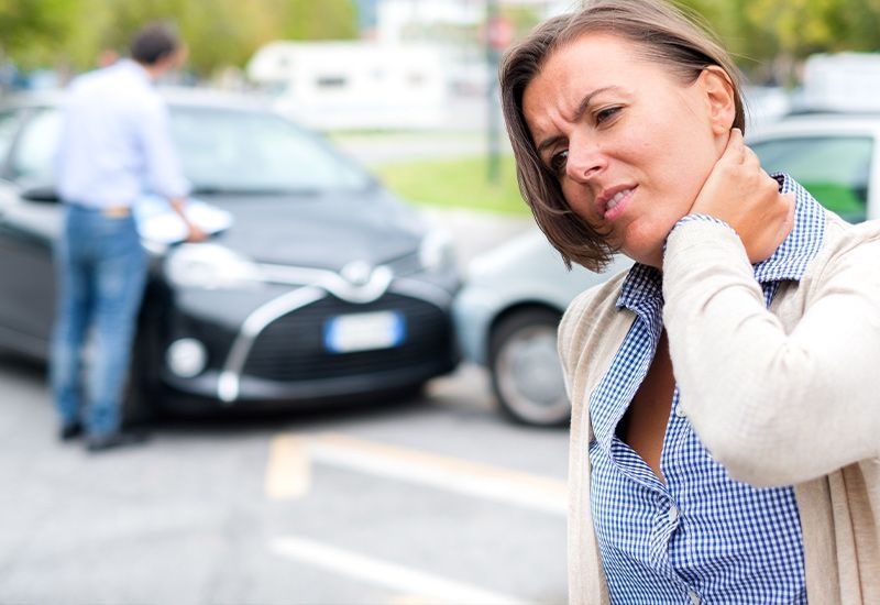 a woman is holding her neck in pain after a car accident .