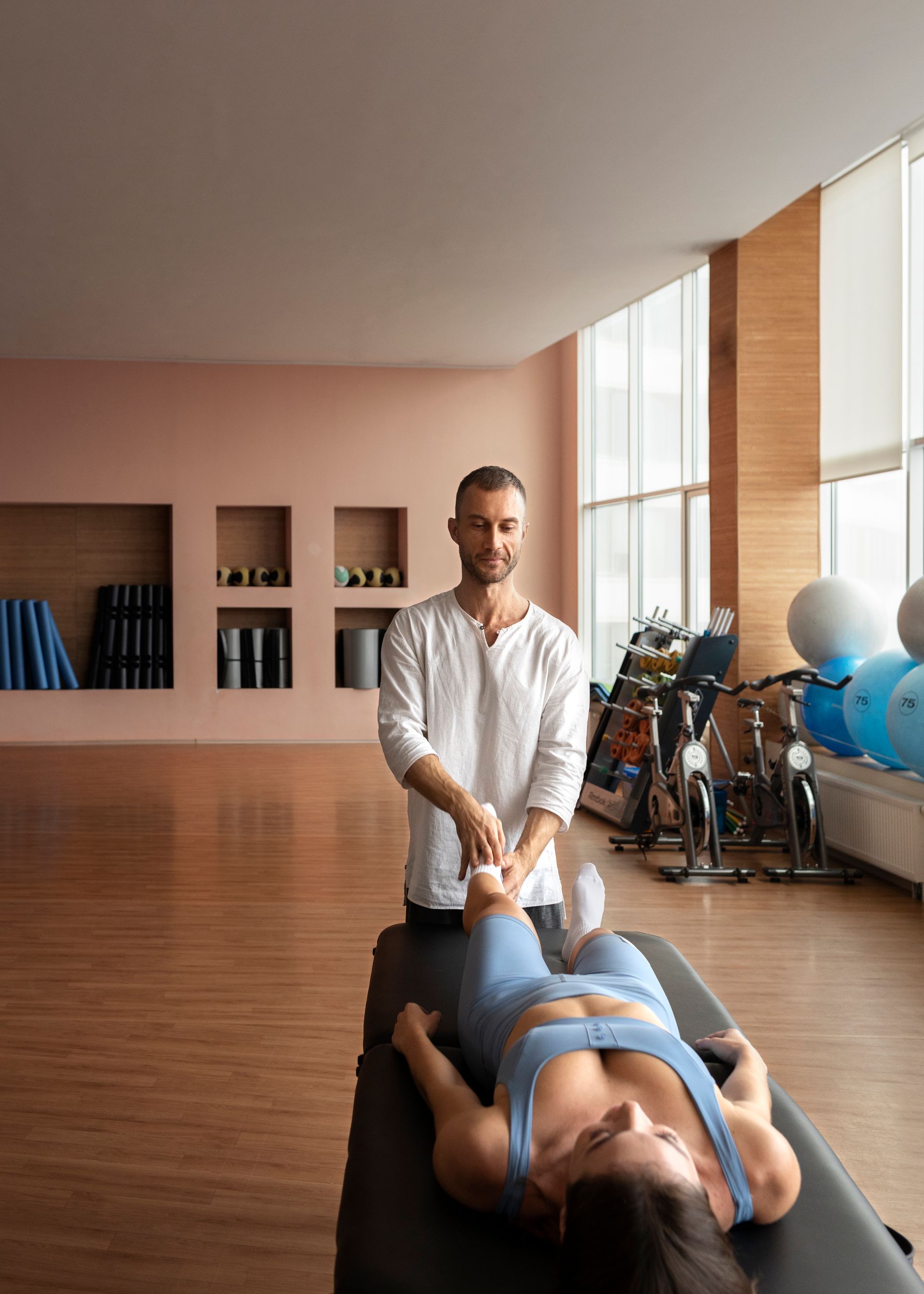 A man is giving a woman a massage in a gym.