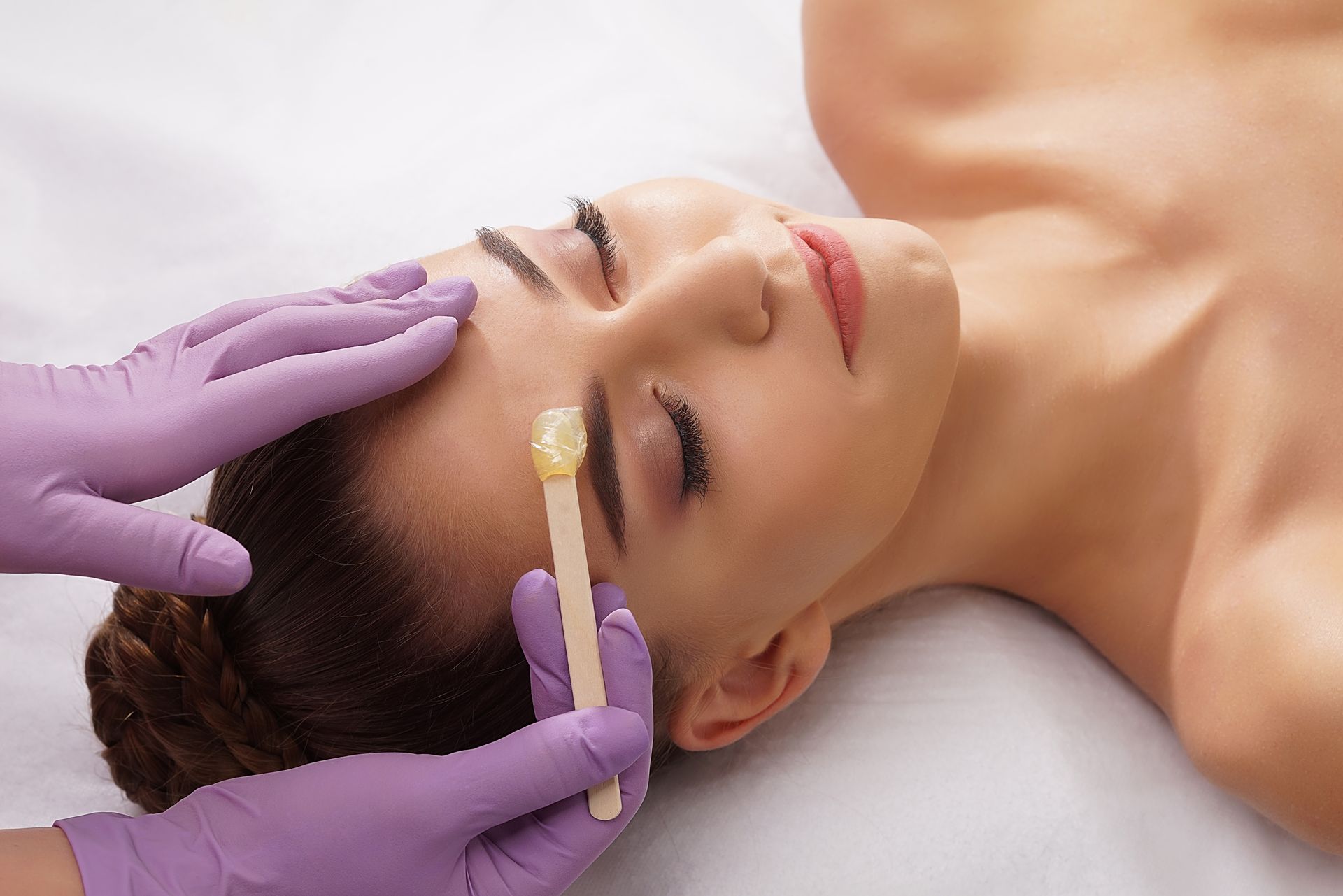 a woman is getting her eyebrows waxed in a beauty salon .