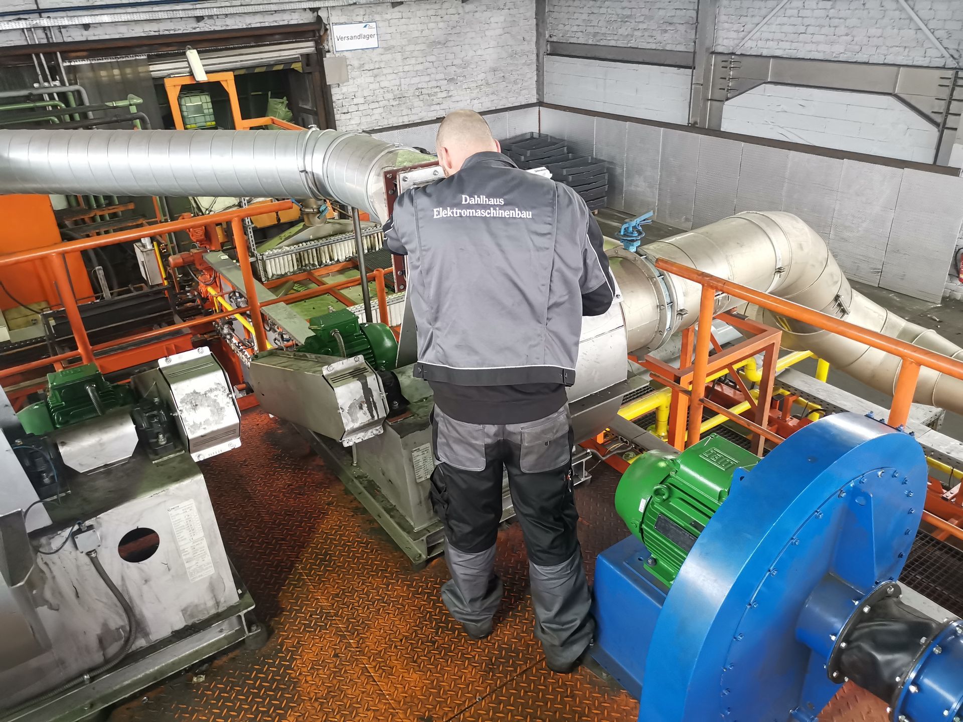 Ein Mann arbeitet in einer Fabrik an einer Maschine.