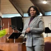 Bishop Miller is standing in front of a podium in a room.