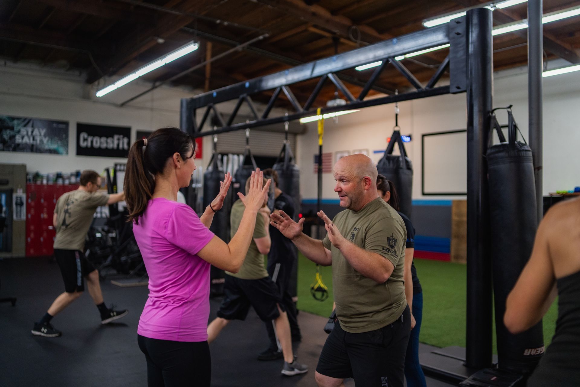 A group of people are standing in a gym talking to each other.