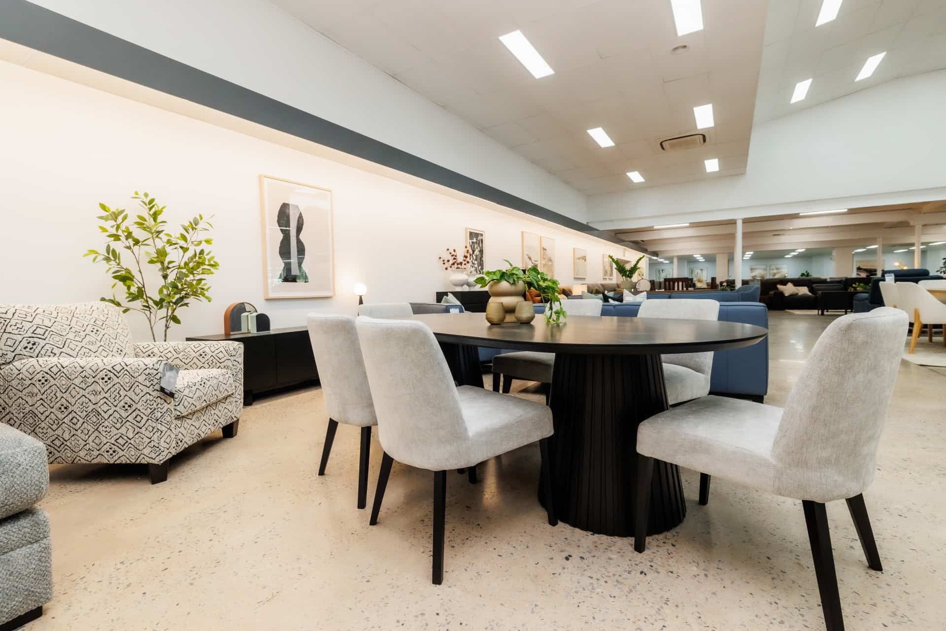 Show room with black dining table and white chairs on display — The Comfort Zone Darwin In Darwin, NT